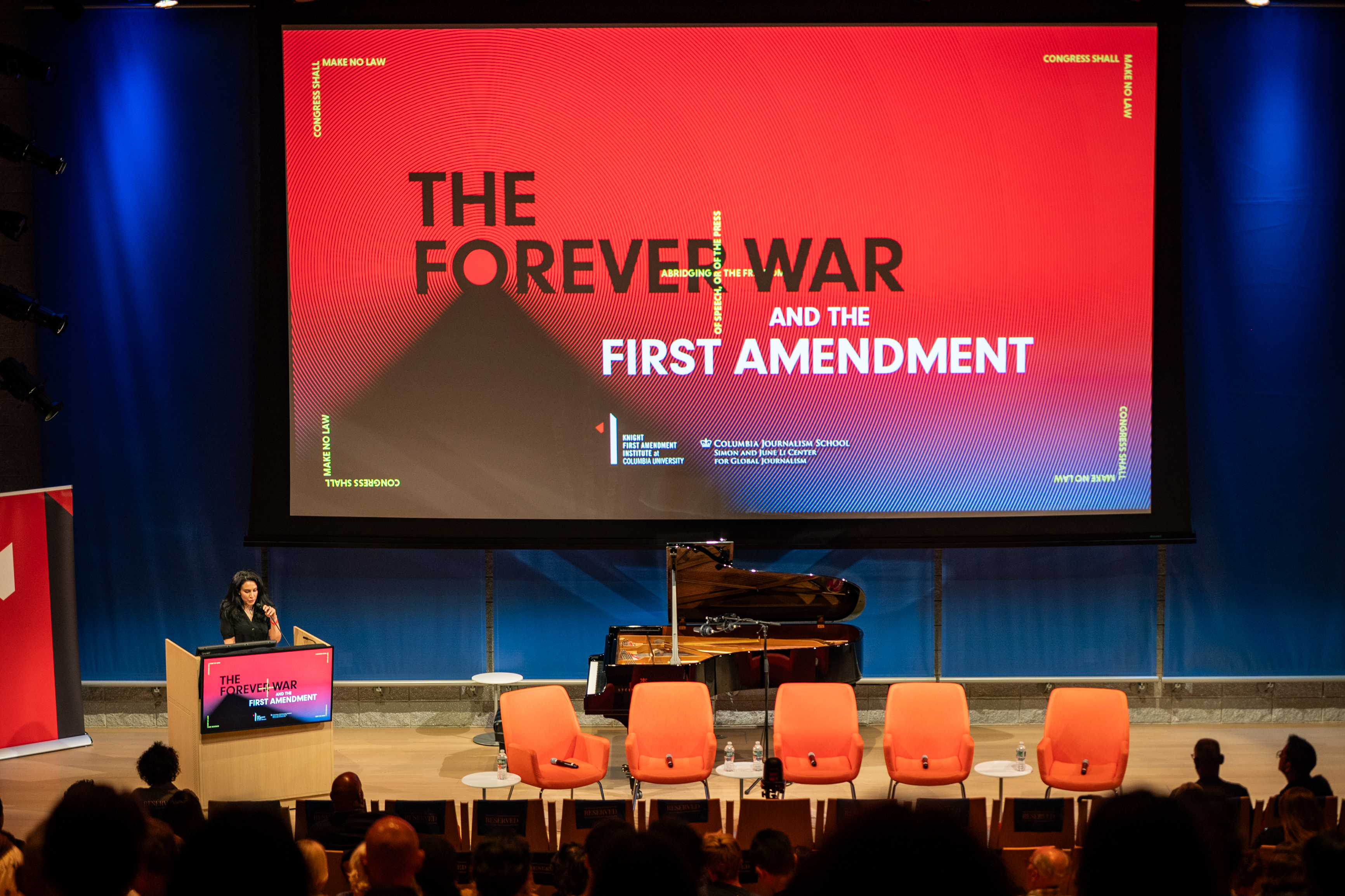 Azmat Khan at the podium with The Forever War and the First Amendment graphic projected on the screen